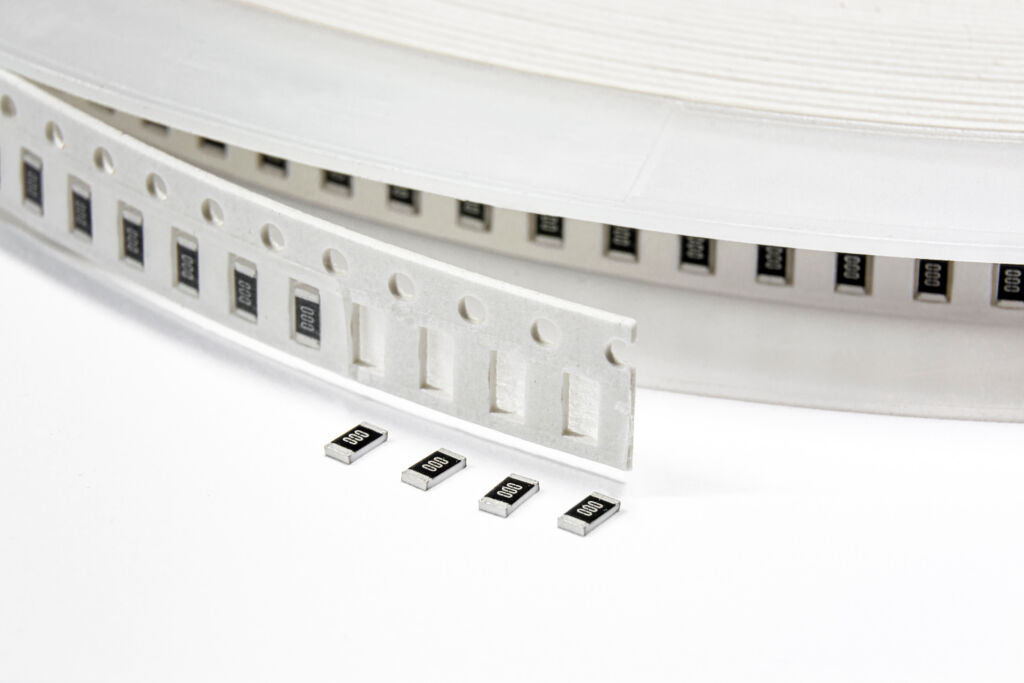 Image of an SMD taping spool showcasing four (4) capacitors