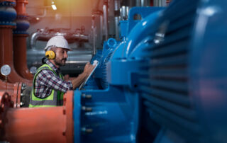 Worker inspecting industrial pump