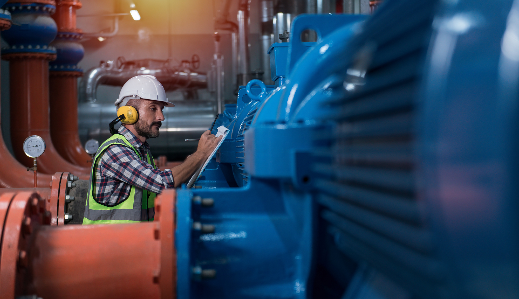 Worker inspecting industrial pump